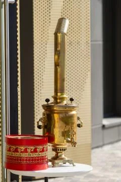 A Russian samovar stands on a table in front of the cafe. Shining on the sun. Au Stock Photos