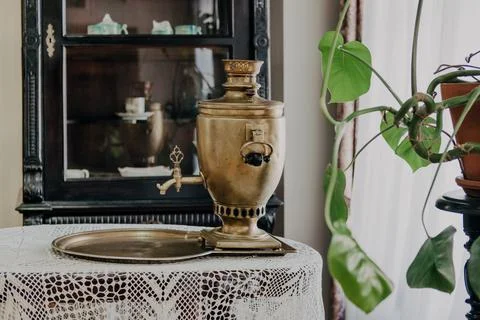 Russian samovar on a table with a tablecloth, against the background of a pan Stock Photos