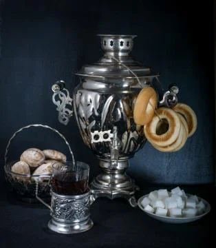 Russian samovar, tea holder, sugar, cake on black Stock Photos
