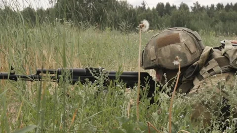 Russian soldiers with machine guns hide in the grass to attack Stock Footage 218434093
