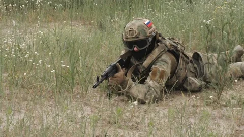 Russian soldiers with machine guns hide in the grass to attack Stock Footage 218434184