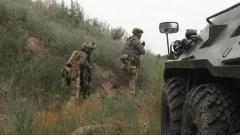 Russian soldiers with machine guns hide in the grass to attack Stock Footage 218434215