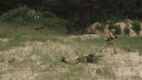 Russian soldiers with machine guns hide in the grass to attack Stock Footage 218434229