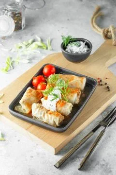 Russian stuffed cabbage rolls served with tomatoes, dill and sour cream in he Stock Photos