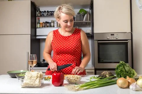 Russian tortoise eating salad while woman looks at him and cuts carrot Foto stock