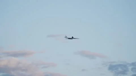 Russian troop, strategic bomber Tu 160 flies in evening blue sky with clouds. Stock Footage