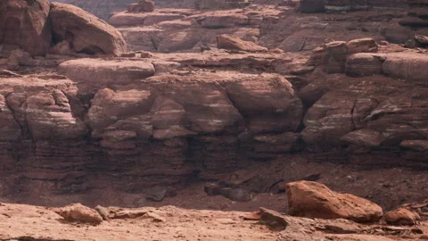 Rust colored rocks and canyon with layers near a dry riverbed Stock Footage 342057995