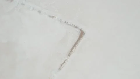 Rust Colored Sediment Streaks Marking White Salt Crust of Dry Lake Bed in South Stock Footage 341072476