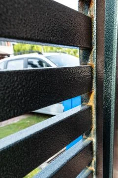 Rust forming on non galvanized epoxy painted steel metal gate Stock Photos