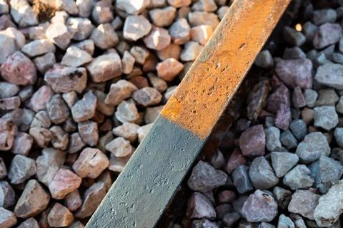 Rust Line on Gravel Bed with Rectangular Steel Bar in Daylight Stock Photos