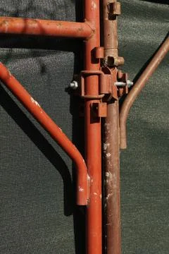 Rust lock at old red wire mesh fence in front of tennis court 스톡 사진