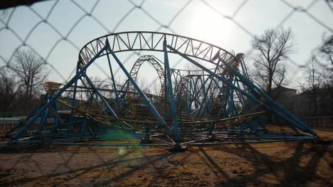 Rust non-working roller coaster in abandoned amusement park on sunny day Stock Footage 303818630