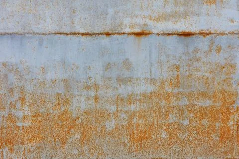 Rust shows through on an old sheet of metal texture painted with gray paint. Stock Photos
