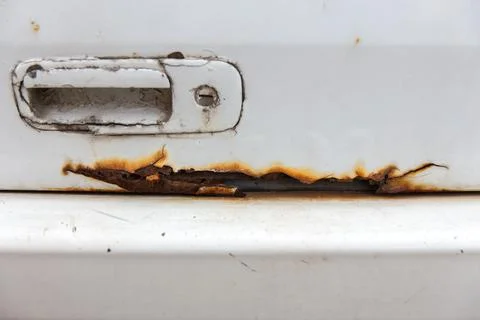 Rust on the side of white old car. Фото