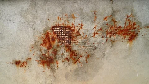 Rust streaks bleeding through cracked plaster wall, revealing metal mesh patch Stock Footage 333417218