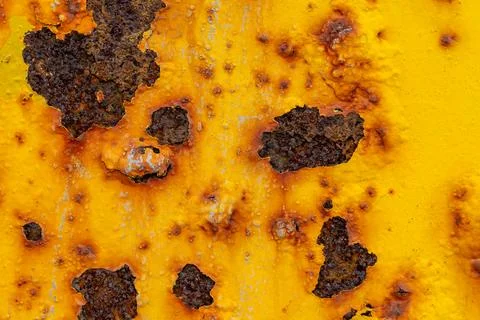 Rust on yellow painted iron caused by moisture. Texture Stock Photos