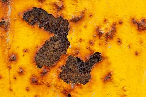 Rust on yellow painted iron caused by moisture. Texture Stock Photos