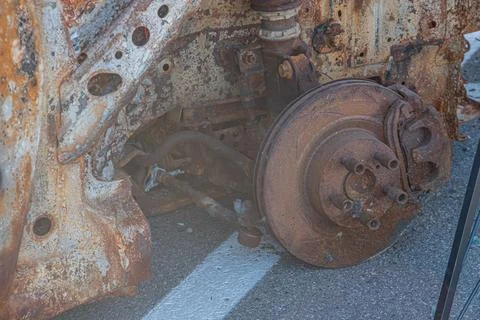 Rusted, angled car on concrete surface in outdoor environment Corroded tire v 스톡 사진