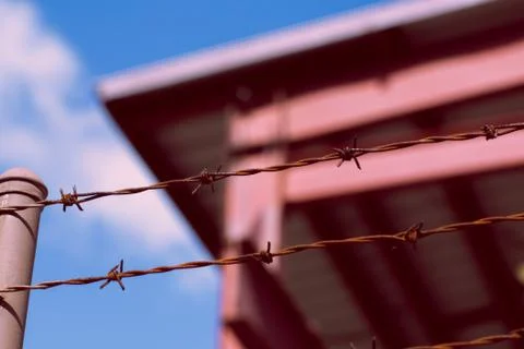 Rusted barbed wire in front of warehouse Stock Photos