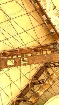 Rusted beams intersect beige panels forming geometric ceiling structure in Stock Photos