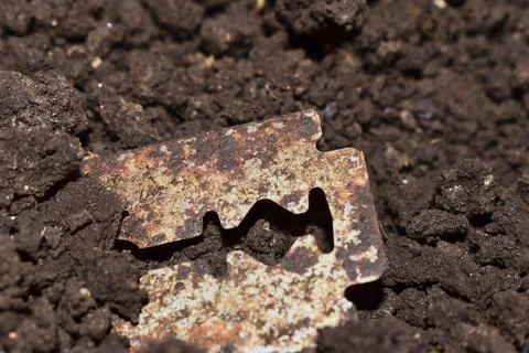 A rusted blade lying in the soil Stock Photos