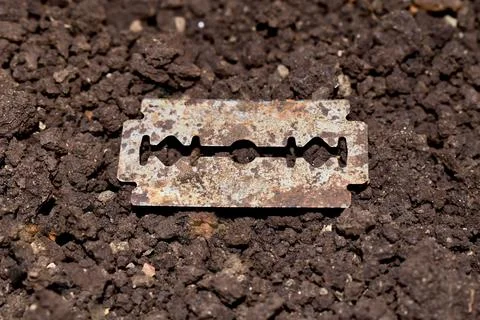 A rusted blade lying in the soil Stock Photos