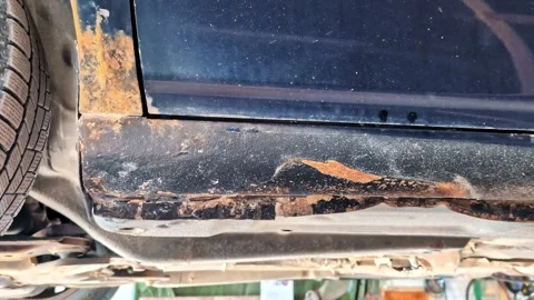 Rusted car side sill and undercarriage corrosion damage on a black vehicle Stock Footage 335892892