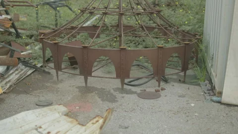 Rusted circular metal frames in overgrown storage yard Stock-Footage 347035597