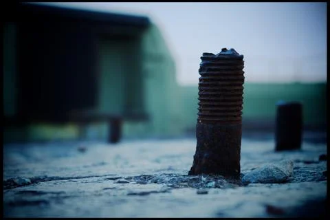 Rusted construction bolt set in cement Stock Photos