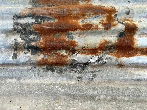 Rusted corrugated metal texture with orange oxidation and weathered zinc surface Stock Photos