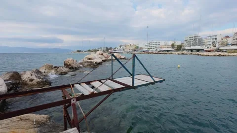 Rusted dock ramp with waves and boats ashore in winter marina scene Stock Footage 337458700