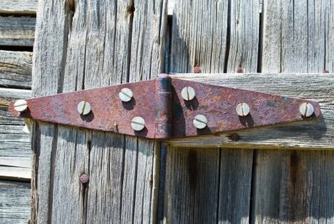 Rusted double hinge on a wooden wall Stock Photos