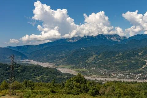 Rusted electric pole in mountains with river panorama and clouds Stock Photos