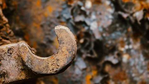 Rusted industrial hook like implement and corroded background 스톡 사진