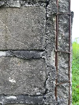 A rusted iron structure can be seen in the corner of the exposed adobe wall. Stock Photos