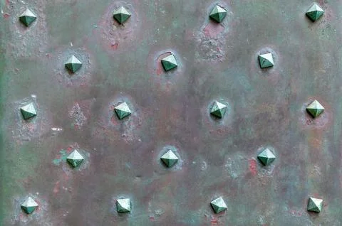Rusted metal panel with rivets arranged in grid pattern Stock Photos