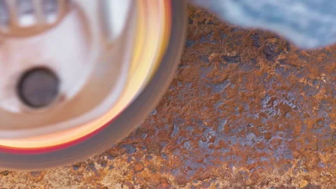 Rusted metal surface is being cleaned with angle grinder and a flap disc, full Stock Footage 272533789