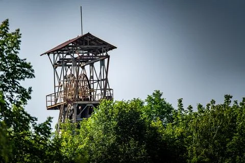 A Rusted Mining Headframe Towering Over Lush Foliage Stock Photos
