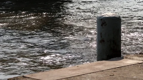 Rusted mooring post and floating concrete dock. Beautiful and peaceful river. Stock Footage 99720556