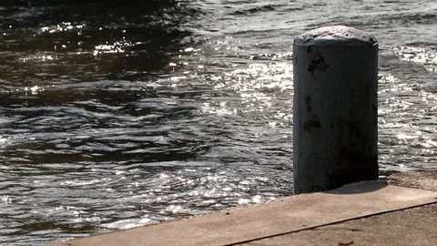 Rusted mooring post and floating concrete dock. Beautiful and peaceful river. Stock Footage 99720616