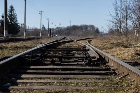 A rusted railway track switch stretching through a rural landscape during a Stock Photos
