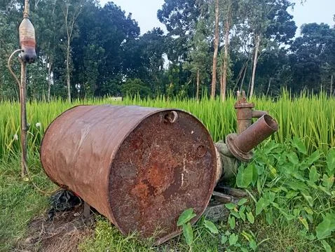 Rusted Water Pump Engine in Green Field Stock Photos