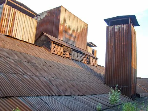 A rustic, aged structure with corrugated metal or wood walls and a patched .. Stock Photos