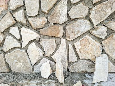 Rustic architectural backdrop exterior wall under construction, clad in unev Stock Photos