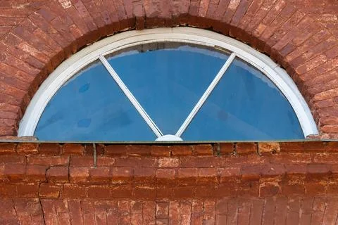 Rustic architectural design featuring a half-circle shaped window Foto stock