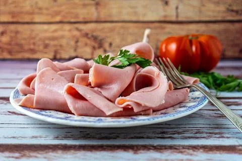 Rustic arrangement of an exquisite ham or prosciutto cotto on a vintage plate Stock Photos