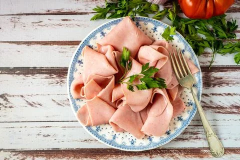 Rustic arrangement of an exquisite ham or prosciutto cotto on a vintage plate Stock Photos