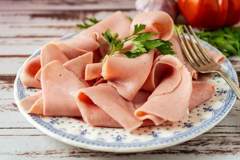 Rustic arrangement of an exquisite ham or prosciutto cotto on a vintage plate Stock Photos