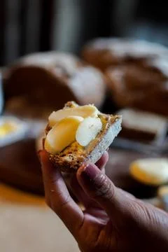 Rustic Artisan Bread Slice with Butter Held by Hand Stock Photos