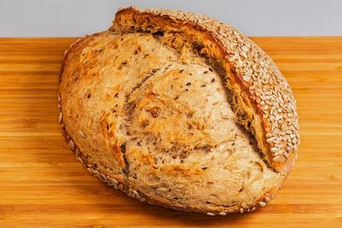 Rustic artisan bread sprinkled with sunflower seeds on cutting board Stock Photos